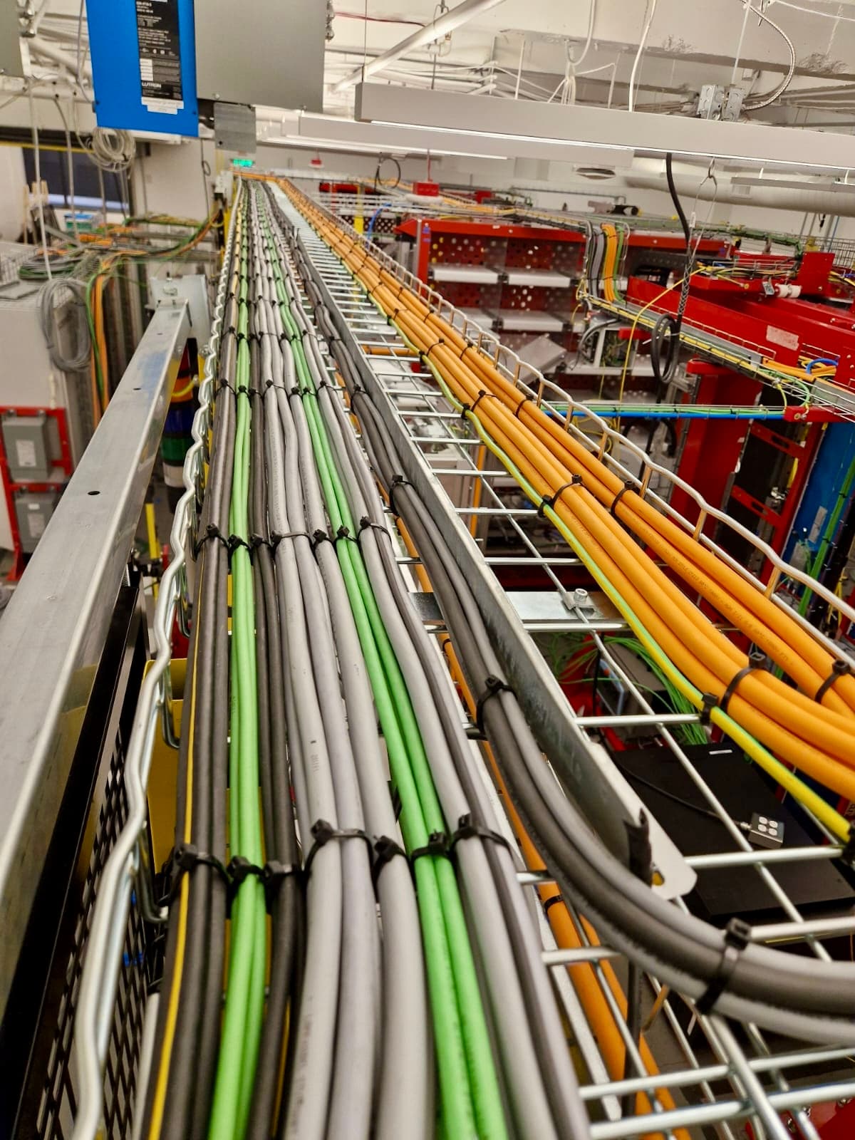 Cable management industriale con cavi organizzati per colore su passerella metallica